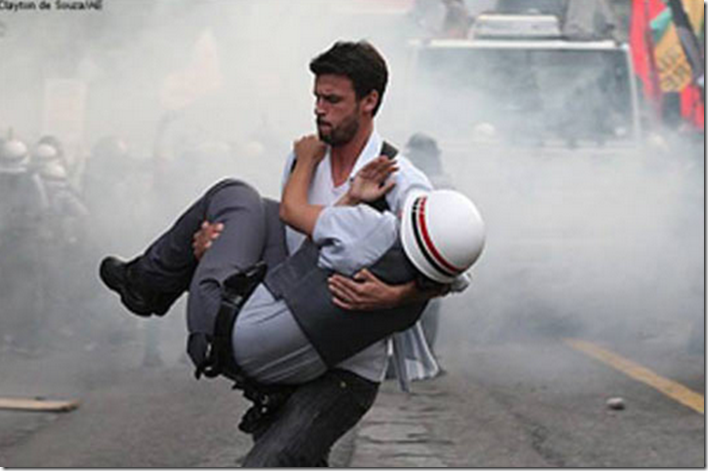 11. Sao Paulo, Brazil, 2012 - Brazilian protester carrying an injured officer to safety