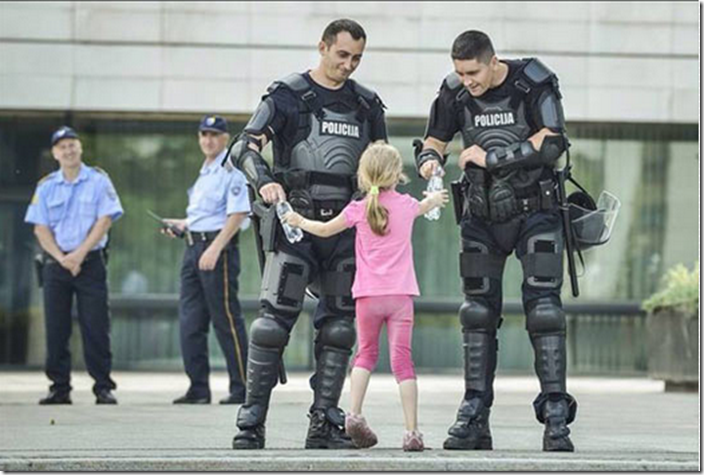 12. Bosnia, 2013 - Girl hands water to two officers