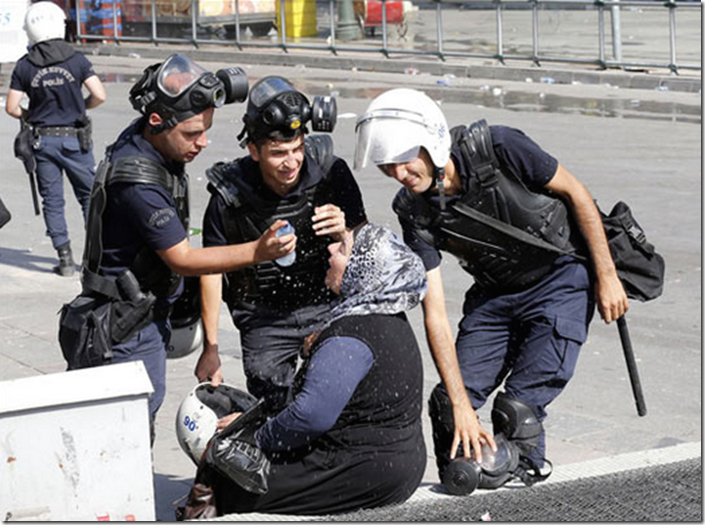 13. Ankara, Turkey, 2013 - Riot police help a womanaffected by tear gas
