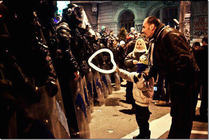 19. Bucharest, Romania, 2012 - A young boy offers a heart-shaped baloon to police. 1